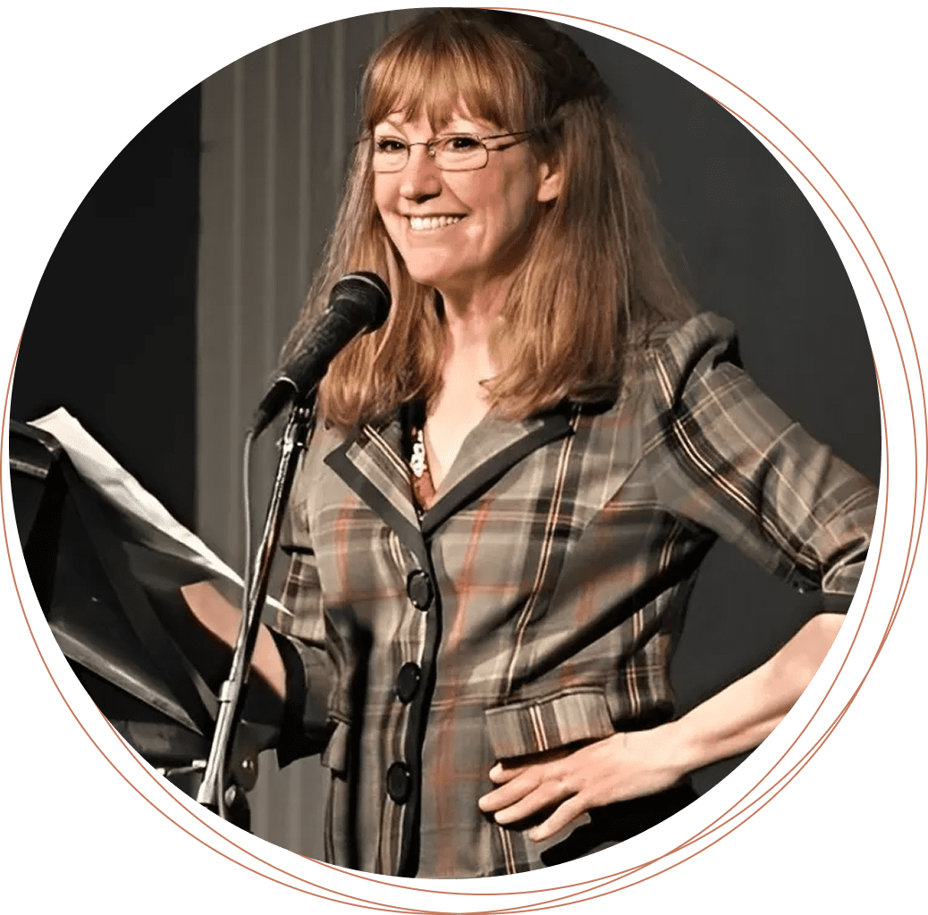 Bev speaking at a microphone, holding papers.