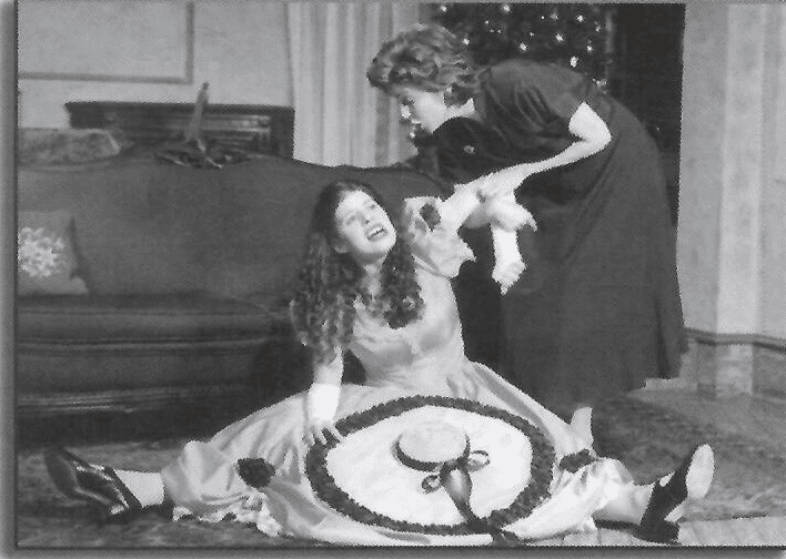 Two women in costume, one on the floor upset and the other above her chastising.